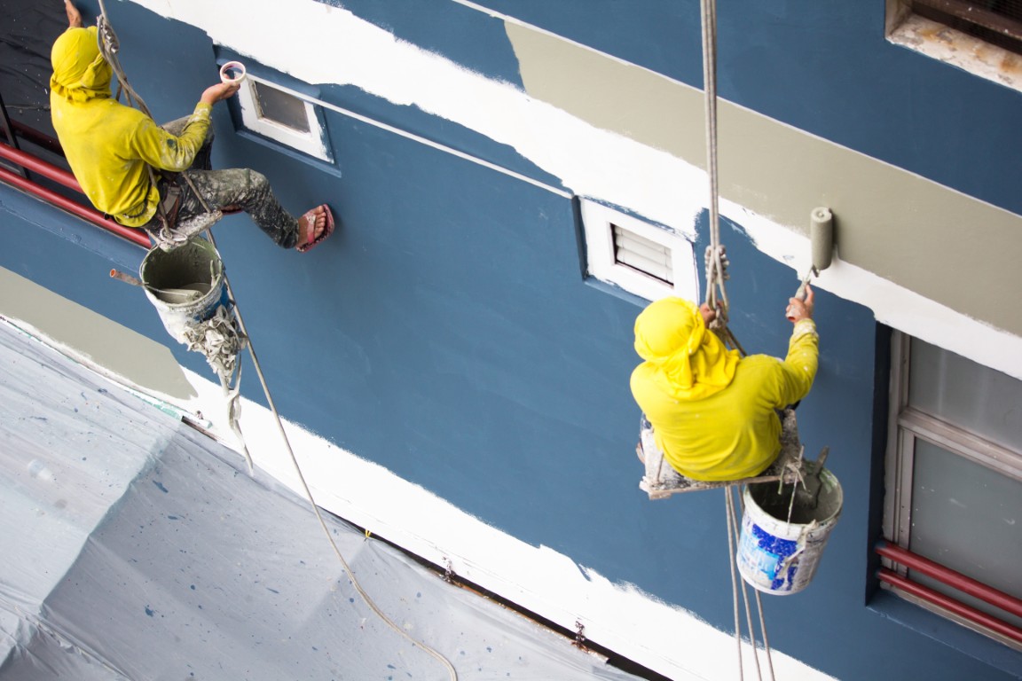 Painters,Hanging,On,Roll,,Painting,Color,On,Building,Wall.,Young