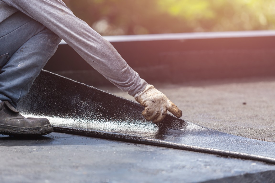 Asia,Worker,Installing,Tar,Foil,On,The,Rooftop,Of,Building.