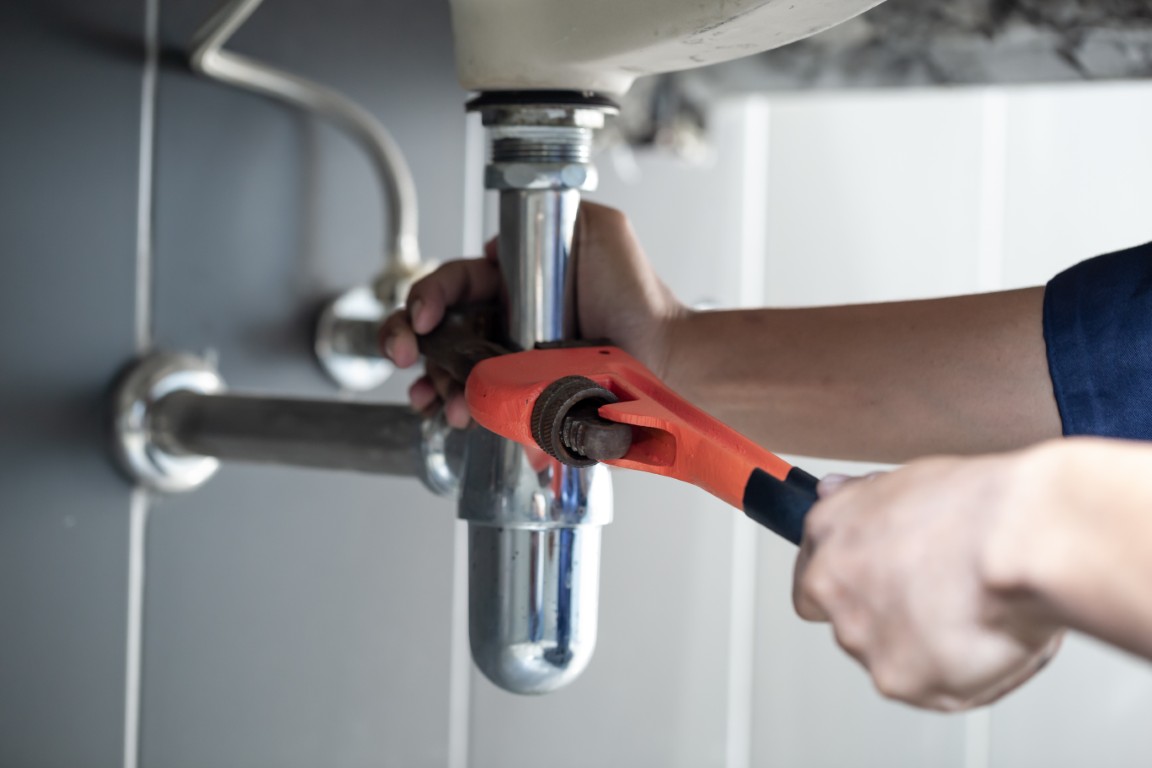 Plumber,Uses,Wrench,To,Repair,Water,Pipe,Under,Sink,There